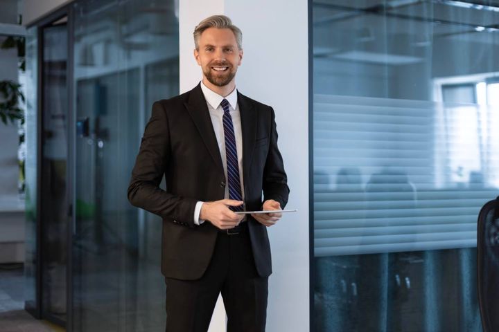 タブレットを持ちながら笑顔を向ける男性