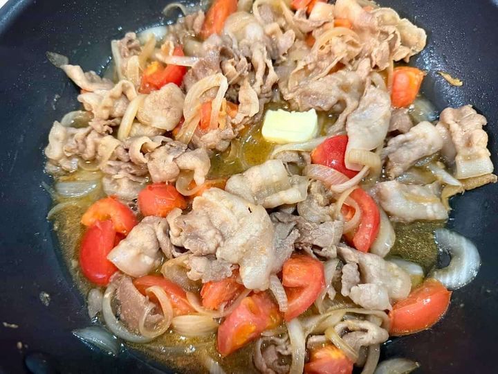 豚肉と玉ねぎをトマトの汁で煮込み、バターを溶かしている様子 トマトバターの洋風しょうが焼き まいのおやつ