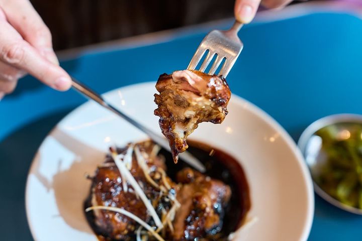 「骨なしスペアリブの黒酢豚」を食べている様子