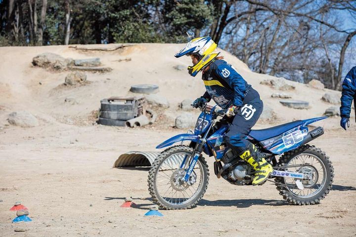 上の野崎選手との身体の位置②と比べるとフロントサスペンションを縮めることに気を取られすぎて前屈み過ぎになり、バイクの挙動が乱れ始めている。これではフロントアップはできても安定して浮かすことができない