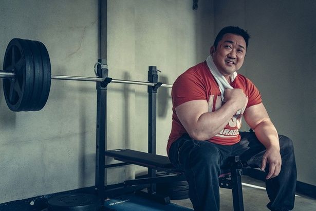 140kgのベンチプレスを持ち上げ、笑顔を見せるマ・ドンソク [c]2025 LOTTE ENTERTAINMENT & BIG PUNCH PICTURES & NOVA FILM ALLRIGHTS RESERVED.