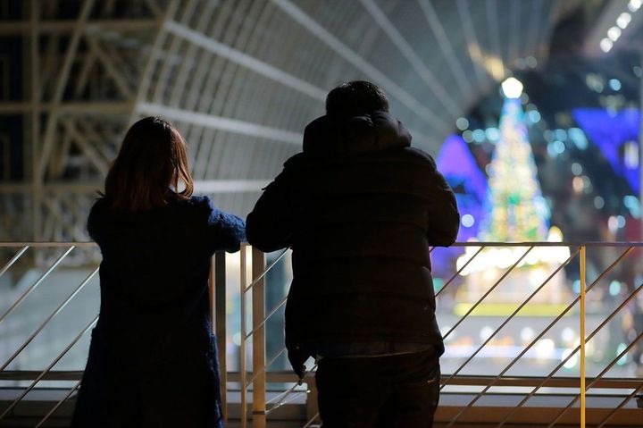 クリスマスのイルミネーションを眺めているカップルの後ろ姿