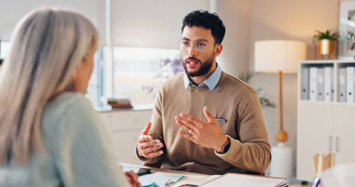 向かい合って座りながら女性と話す男性