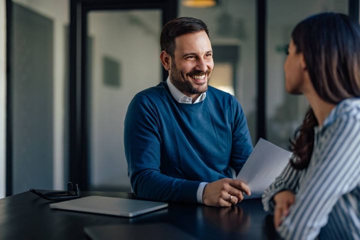 会議室で同僚の女性と話す男性