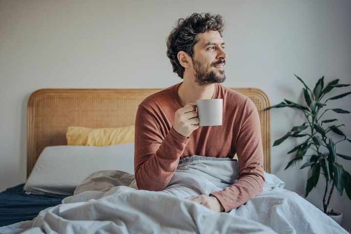 コーヒーを飲む寝起きの男性