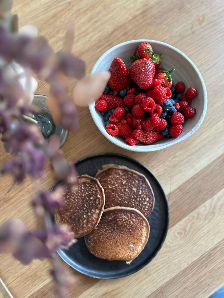 バナナと豆乳ヨーグルト、全粒粉のパンケーキ、ベリーたっぷりの朝食。