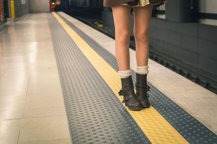 駅のホームに立っている女性