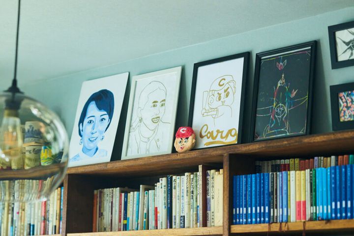 本棚の上には娘たちが描いた岡本さんの肖像画を飾って