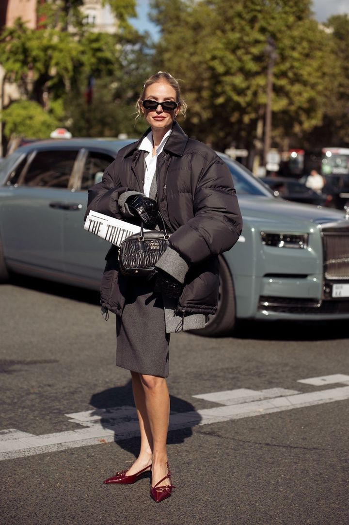 シックなスーツスタイルとばさっと羽織ったダウンの抜け感が好バランス。