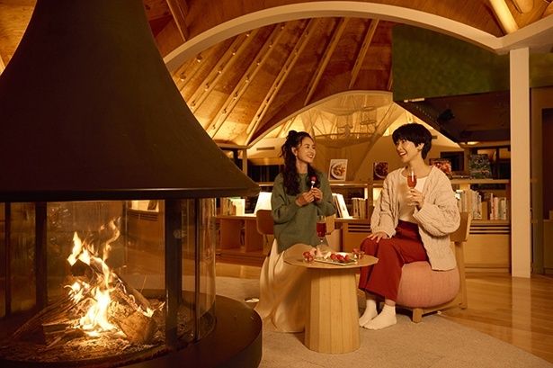 暖炉の灯る空間でくつろぎのひとときを過ごす