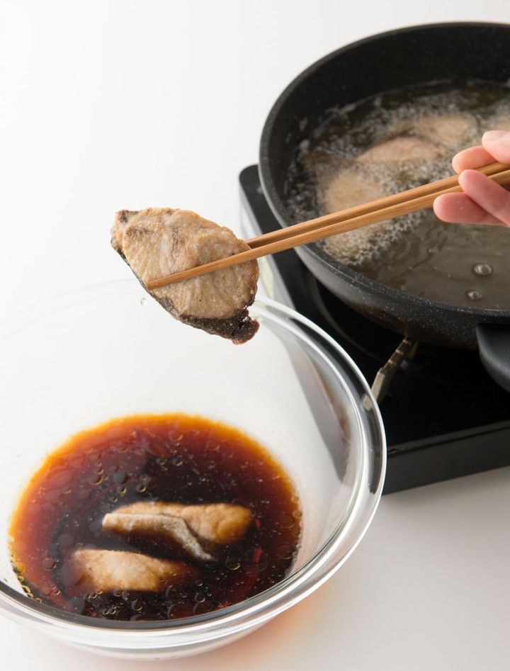 ぶりを揚げるときは、そばに漬け汁をおいてスタンバイ。揚がったら油をよくきり、すぐさま汁の中へ。熱いうちなら味がよくなじむ。