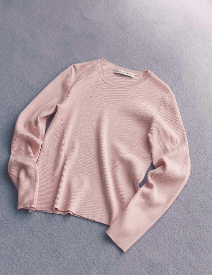 マイルドなピンクが肌になじみ血色感をアップ。窮屈さのない着心地のよさとスタンダードなデザインで、オンオフ着まわせる。ニット（ナノ・ユニバース／ナノ・ユニバースカスタマーサービス）