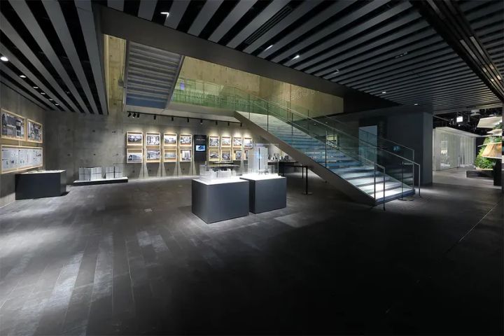 展示スペースのインテリア写真。階段、模型、写真が展示されており、スタイリッシュな雰囲気。
