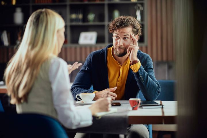 同僚の女性の話を聞く男性