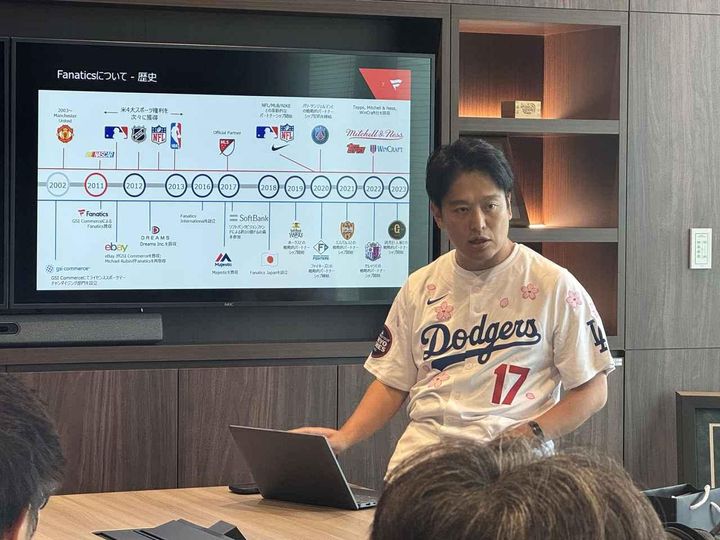 画像: ©Fanatics Japan Fanaticsの歩んだ歴史や日本法人が行う事業について語る川名氏。同氏が着用するドジャースのユニフォームは、村上隆氏とのコラボレーション仕様で、MLB開幕戦の際に販売され、即日完売となった人気アイテムだ。