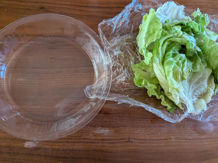 2．レタスをラップの上にずらし、耐熱皿にたまった水分は捨てる。