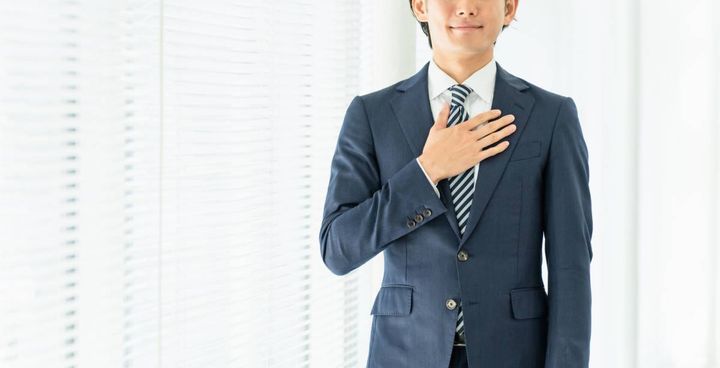 胸に手を当てる人