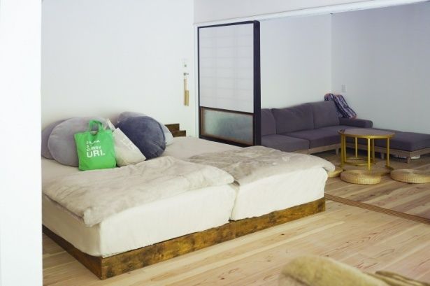 ふかふかのベッドと奥のソファでごろごろ過ごせる、プライベートサウナ旅にぴったりのくつろぎ空間