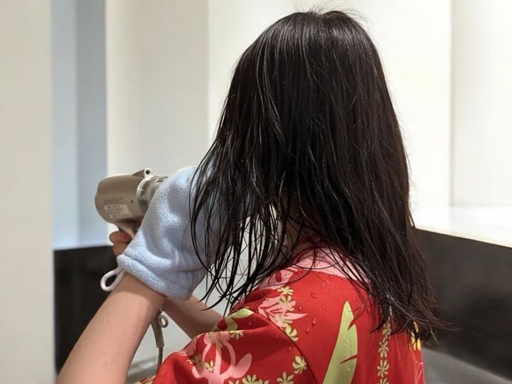 ドライヤーをかけながら手袋で髪をなでる