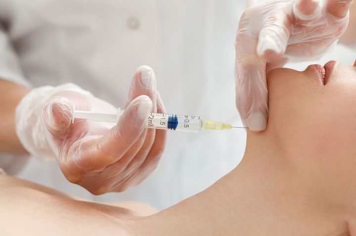 患者の顎に注射をする美容師