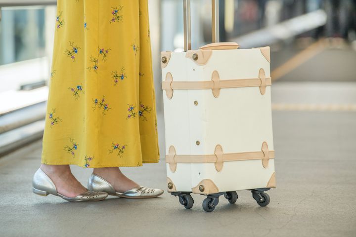 スーツケースと女性の足元