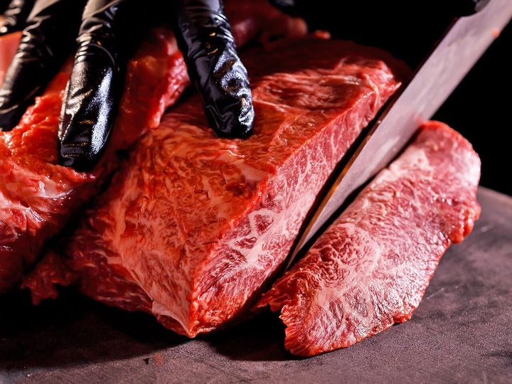 六本木『焼肉 東京24区』の肉をカットしている様子