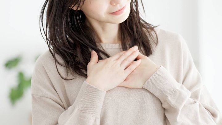 胸に手を当てる人