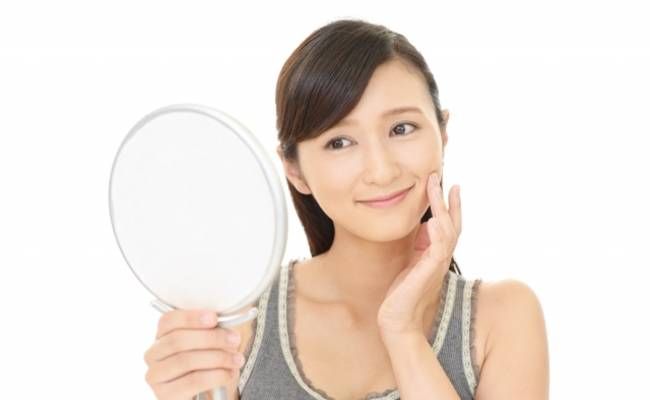鏡を見てうれしそうにしている女性のイメージ