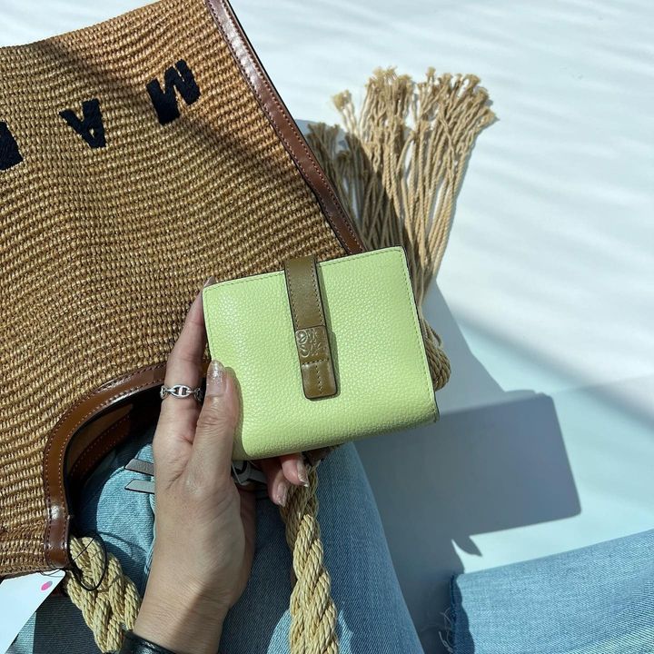 ロエベの財布を持つ女性