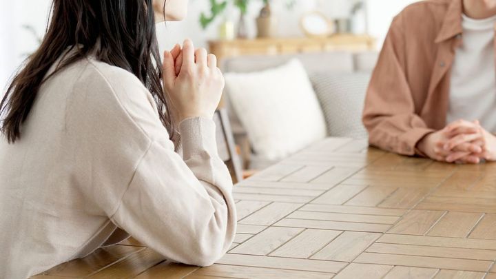 リビングルームで真剣な会話をしているカップル