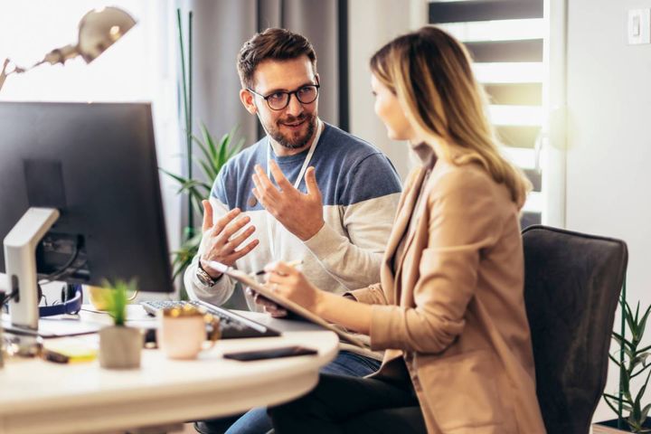 デスクで話し合う男女