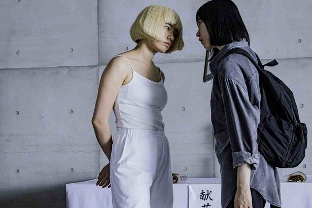 早苗と瑠美が互いの顔を無表情で見つめ合う [c]2026 K2P