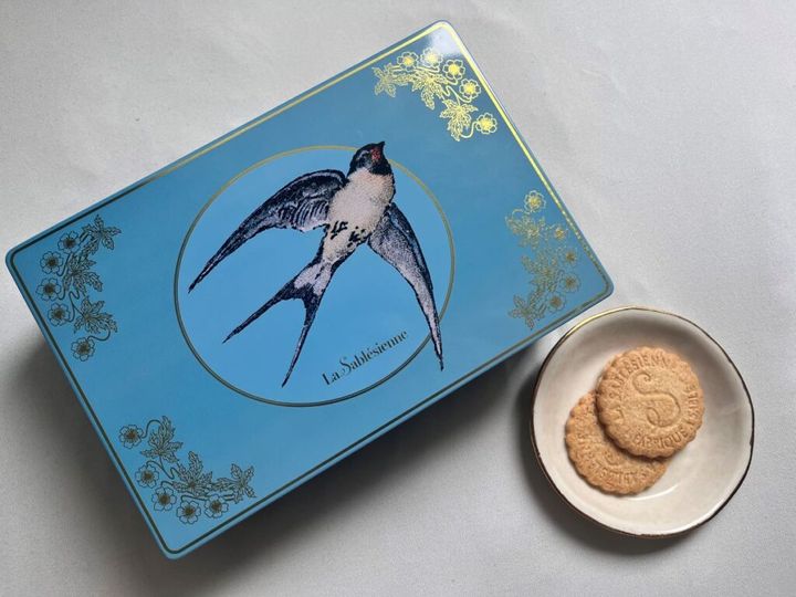 ツバメの絵が描かれた青いクッキー缶とサブレ