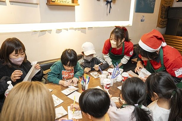 パートナーにレクチャーを受けながらコーヒーかすの抽出液でペインティング