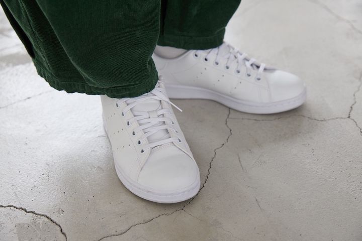 裾タック入りのコーデュロイ素材のボリュームパンツにアディダスのスタンスミスの白スニーカーを合わせた足もとコーデ