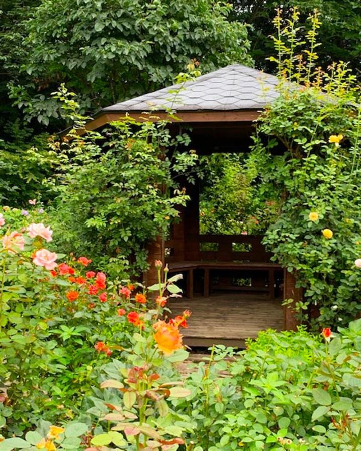 日本の高原をオレンジや黄色のビタミンカラーのバラが彩ります。ガゼボの周りも半つる性のバラで華やかに。（筆者撮影）