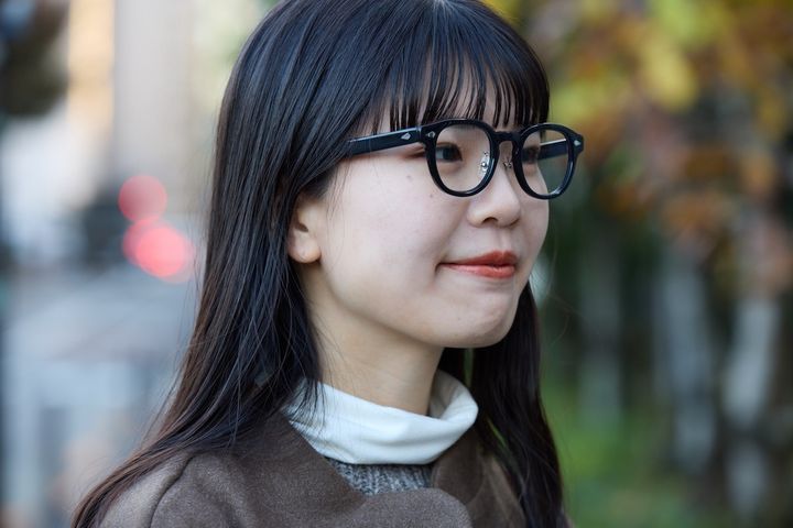 幾何学柄ニットと黒縁メガネを合わせた、冬のナチュラルスタイルの顔まわり