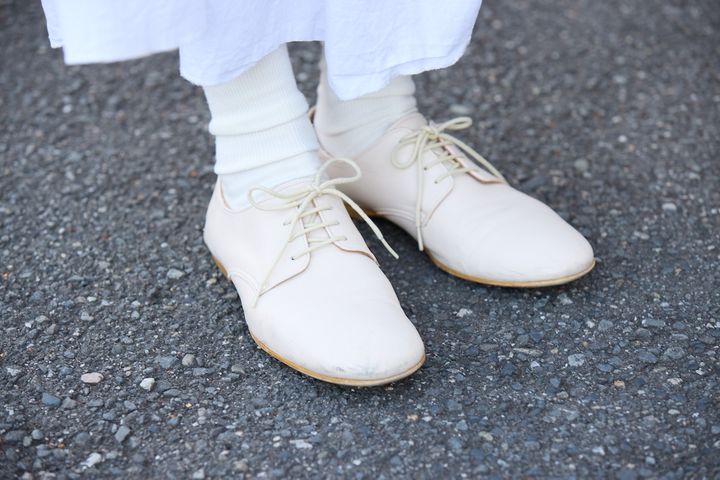 ギャザースカートに合わせた、軽やかなホワイトレザーのレースアップシューズ
