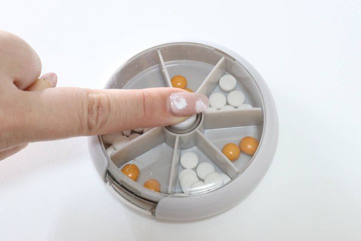 スリーコインズの回転ピルケースのボタンを押す