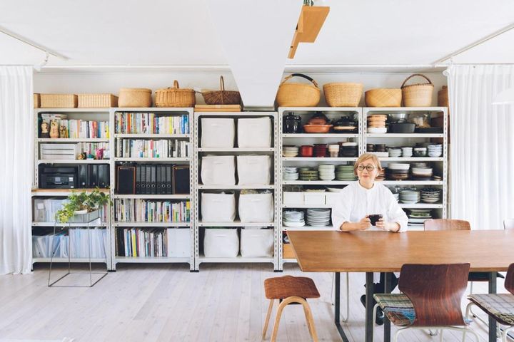 南北に大きな窓のある明るく風通しのいいLDK。壁一面に「D&DEPARTMENT」の「工業用スチールシェルフ」を並べて収納不足を解決。「ものが見えていると『次の食事会ではこのお皿を使おう』などと意識できて、死蔵品がなくなります」