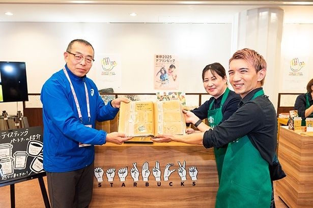 ファイリングしたメッセージをデフリンピック準備運営本部のGMO兼大会統括部長の北島さんへ贈呈