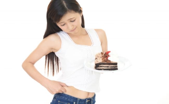 お腹周りの脂肪を気にする女性