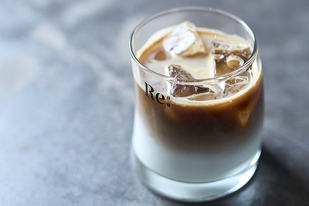 アイスカフェラテ(550円)。韓国製のオリジナルグラスは、傾いた円柱型がユニーク