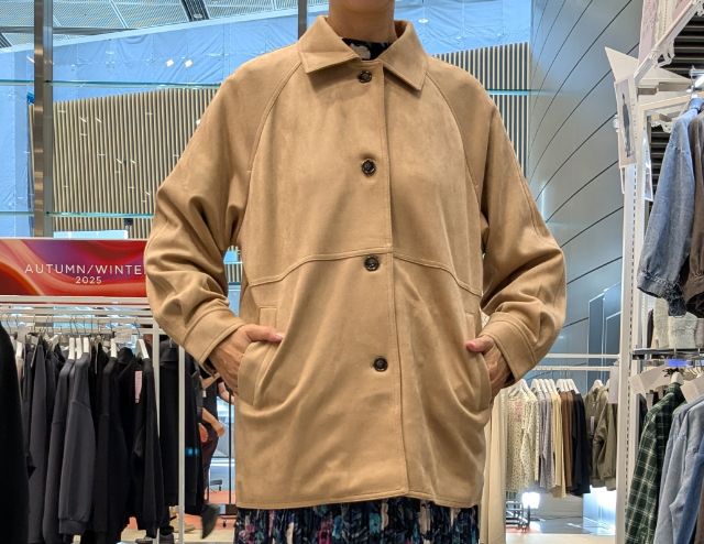 フェイクスエード調のステンカラーコートを着用したコーデ