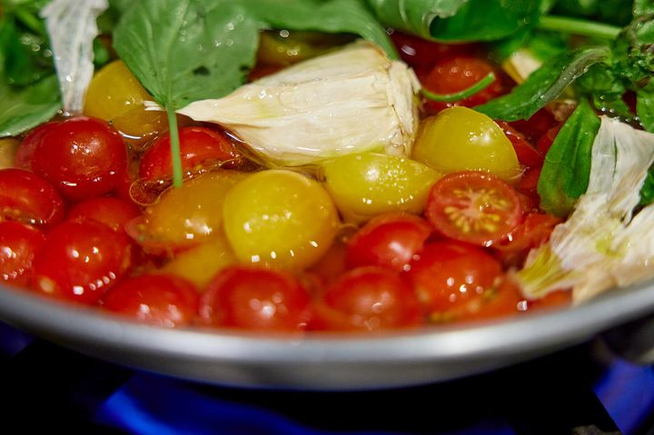 ミニトマト、にんにく（皮ごと）、バジル（茎ごと）をフライパンにいれ、強火にかける