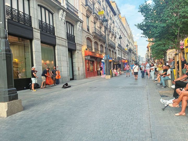 路上で演奏をする人と、眺める人々