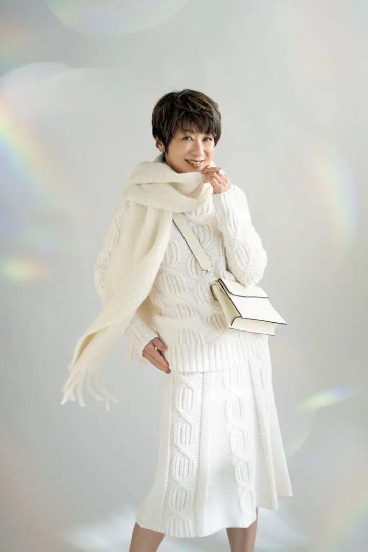 ニット¥357,500、スカート¥327,800／マーロ（ウールン商会）、マフラー¥68,200 ／ロレーナ アントニアッツィ（ウールン商会）、人差し指のリング¥72,600、中指のリング¥97,900 ／ともにヒロタカ（ヒロタカ 表参道ヒルズ）、バッグ¥346,500 ／ヴァレクストラ（ヴァレクストラ・ジャパン）