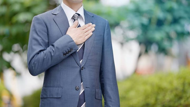 胸に手を当てる人