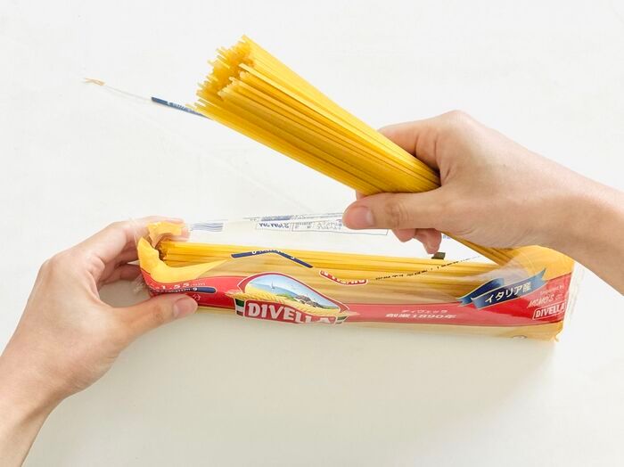 パスタ袋の中からパスタを取り出している