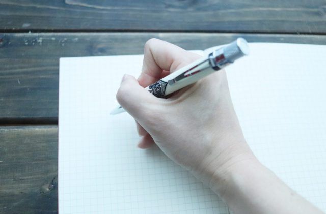 ノートに書く人の手